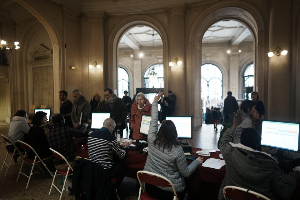 People wait to register to vote in a citywide mini-referendum: "For or against self-service scooters in Paris?" at the city hall of the 10th district of Paris, Sunday, April 2, 2023. The wheels may be about to come off Paris' experiment with for-hire electric scooters. That's if Parisians vote on Sunday to do away with the 15,000 opinion-dividing micro-vehicles. (AP Photo/Thibault Camus)