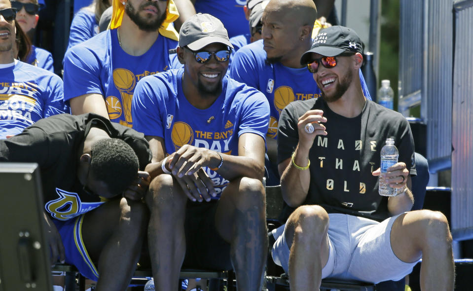 Kevin Durant and Stephen Curry laugh it up at Golden State’s victory parade. (AP)