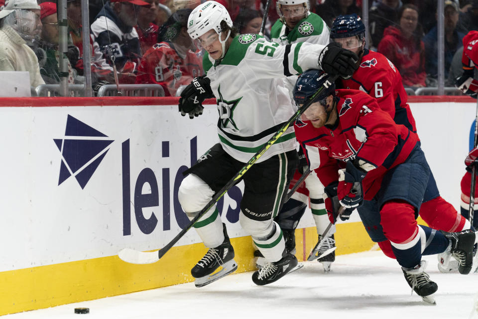 Dallas Stars center Wyatt Johnston (53) and Washington Capitals defenseman Nick Jensen (3) battle for control of the puck during the second period of an NHL hockey game, Thursday, Dec. 7, 2023, in Washington. (AP Photo/Stephanie Scarbrough)