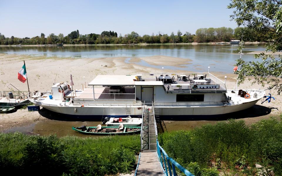 A boat moored on dry waters on the Po River in the province of Rovigo, Italy - Ciancaphoto Studio 