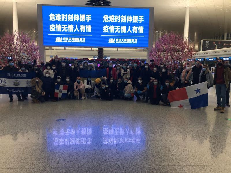 Tourists from around the world pose for a photograph at the airport in Wuhan