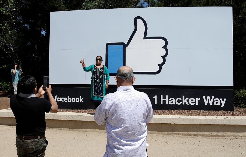 Visitors take photos in front of a sign at Facebook headquarters in Menlo Park, Calif., Thursday, April 25, 2019.