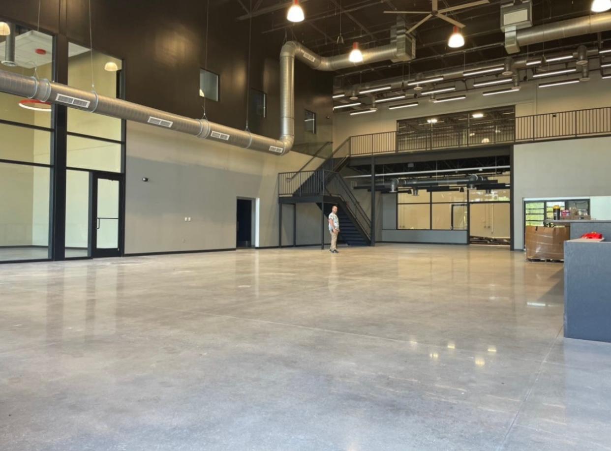 Icarus Brewing owner Jason Goldstein stands in the center of the new Brick location's massive tasting room, as a scale to show how big the room truly is.