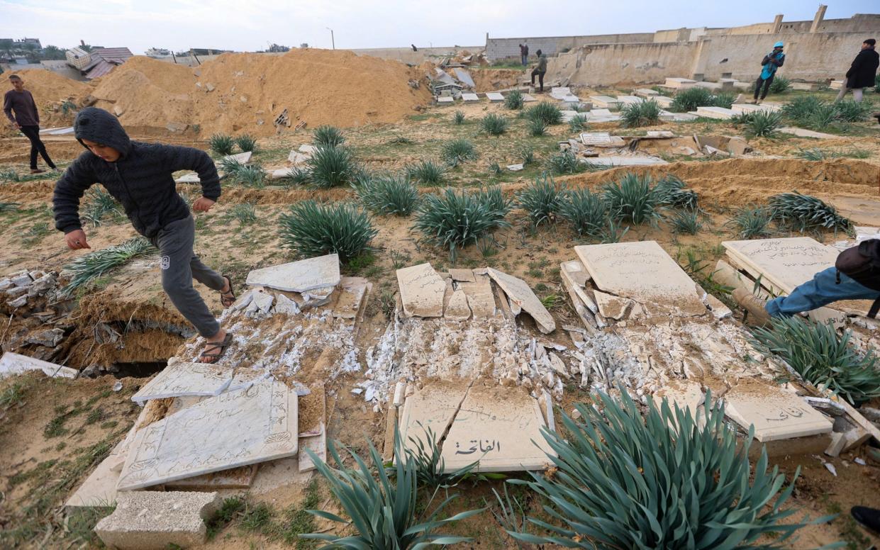 Damaged graves at a cemetery in Khan Younis amid the ongoing conflict between Israel and Hamas in Gaza