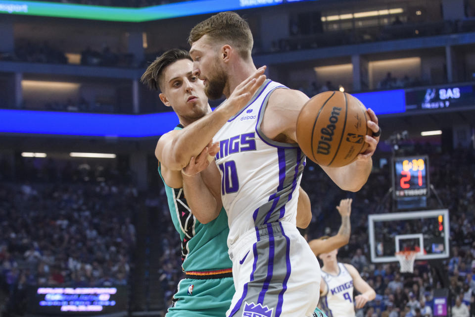 Sacramento Kings forward Domantas Sabonis, right, is guarded by San Antonio Spurs forward Zach Collins during the first quarter of an NBA basketball game in Sacramento, Calif., Sunday, April 2, 2023. (AP Photo/Randall Benton)