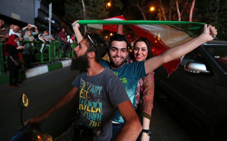 Iranian wave the national flag during celebration in northern Tehran on July 14, 2015, after Iran's nuclear negotiating team struck a deal with world powers in Vienna. 