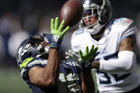 Seattle Seahawks wide receiver Tyler Lockett, left, catches a pass in front of Tennessee Titans strong safety Bradley McDougald for a 51-yard gain during the first half of an NFL football game, Sunday, Sept. 19, 2021, in Seattle. (AP Photo/John Froschauer)