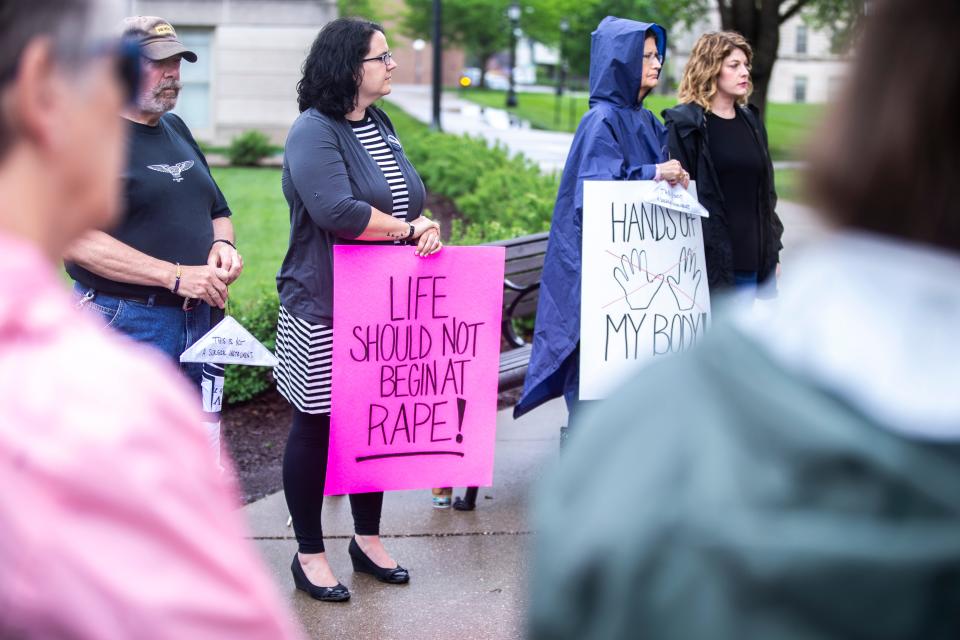 A woman holds a sign reading, "Life should not begin at rape!" during a protest to protect women's reproductive rights.
