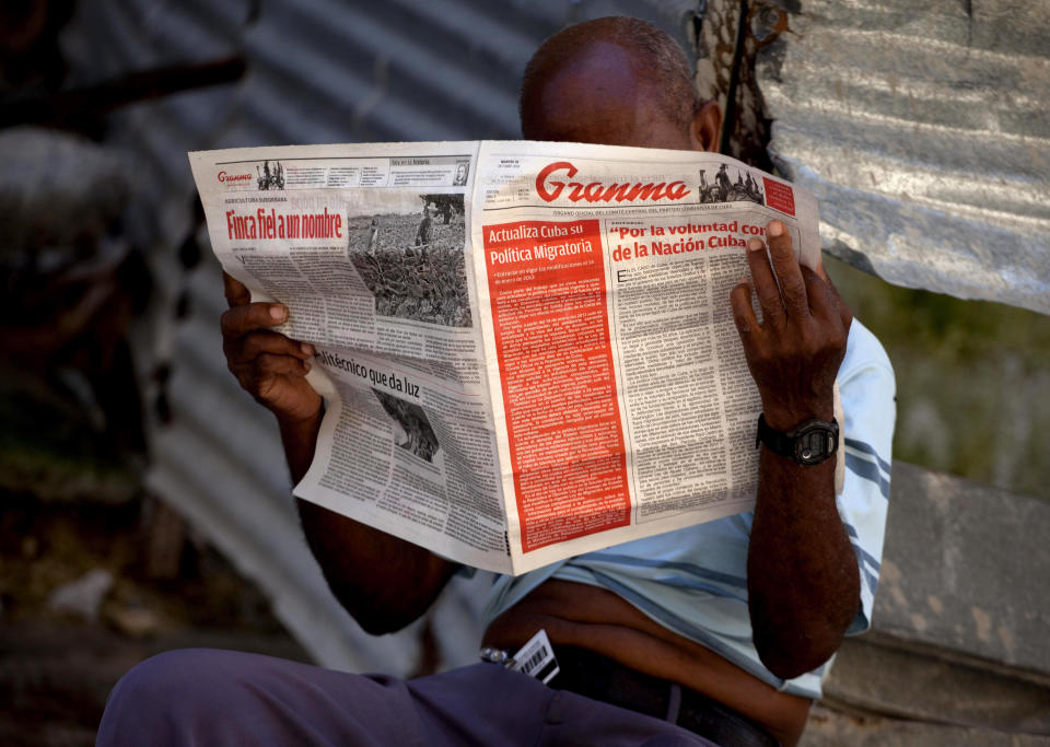 A man reads a Tuesday copy of the Communist Party newspaper Granma which published the new migratory policy that will no longer require islanders to apply for an exit visa on it's front page, in Havana, Cuba, Tuesday, Oct 16, 2012. The Cuban government announced Tuesday that it will eliminate the bureaucratic procedure that has been a major impediment for many seeking to travel overseas for more than a half-century. (AP Photo/Ramon Espinosa)