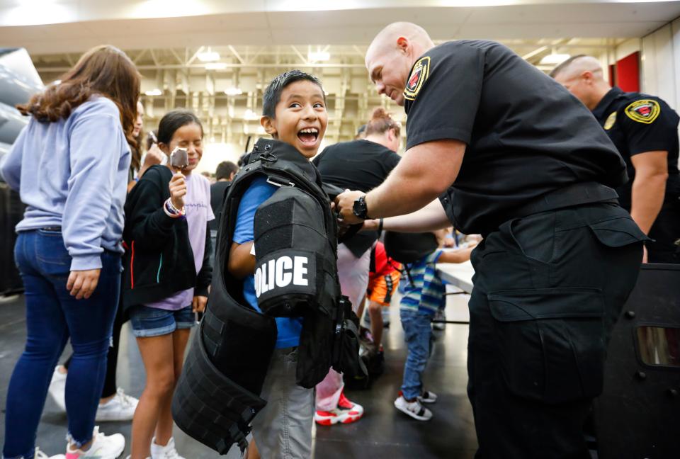 Jair Cruz, 9, smiles as he tries on tactical equipment from the Springfield Police Department Special Response Team during the Springfield Public School Back To School Bash at the Springfield Expo Center on Saturday, July 30, 2022.