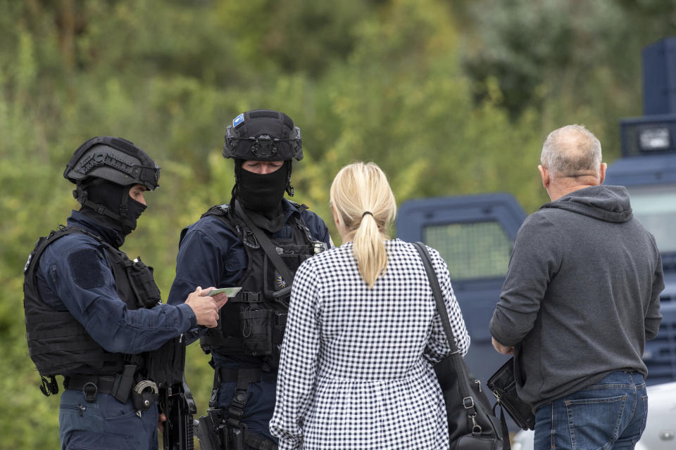 Kosovo police officers check ID cards at a cross road leading to the Banjska Monastery during a ongoing police operation in the village of Banjska, Kosovo, on Monday, Sept. 25, 2023. Kosovo on Monday observed a day of mourning for the Kosovar Albanian police officer killed by Serb gunmen who then barricaded themselves in an Orthodox monastery in a siege that further raised tensions as the two wartime foes seek to normalize ties. In the north, where most of Kosovo’s ethnic Serb minority lives in four municipalities around Mitrovica, police were patrolling in search of the armed assailants after they left the monastery. (AP Photo/Visar Kryeziu)