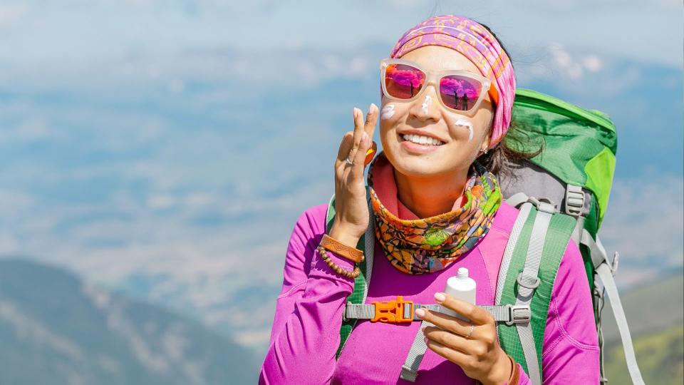 Woman applying sun cream during a hike