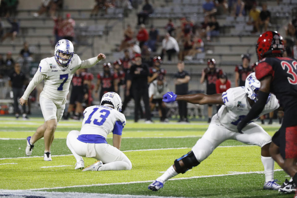 Middle Tennessee punter Kyle Ulbrich (13) holds the ball as place kicker Zeke Rankin (7) kicks a field goal against San Diego State during the second half of the Hawaii Bowl NCAA college football game, Saturday, Dec. 24, 2022, in Honolulu. (AP Photo/Marco Garcia)