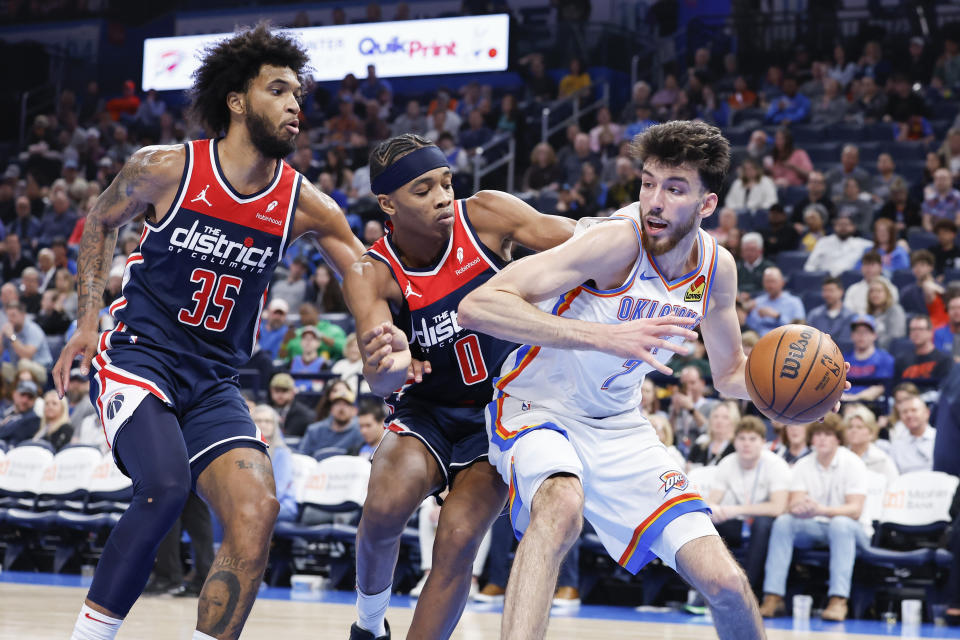 Feb 23, 2024; Oklahoma City, Oklahoma, USA; Oklahoma City Thunder forward Chet Holmgren (7) is defended by Washington Wizards forward <a class="link " href="https://sports.yahoo.com/nba/players/5959/" data-i13n="sec:content-canvas;subsec:anchor_text;elm:context_link" data-ylk="slk:Marvin Bagley III;sec:content-canvas;subsec:anchor_text;elm:context_link;itc:0">Marvin Bagley III</a> (35) and guard Bilal Coulibaly (0) on a drive during the second half at Paycom Center. Mandatory Credit: Alonzo Adams-USA TODAY Sports