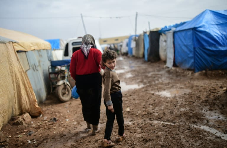 Refugees walk between tents near the Turkish border crossing gate in Bab al-Salama after fleeing the northern embattled Syrian city of Aleppo on February 6, 2016