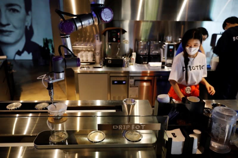 Drip Bot makes a cup of coffee as an employee wearing a mask to avoid the spread of the coronavirus disease (COVID-19) works at a cafe in Seoul