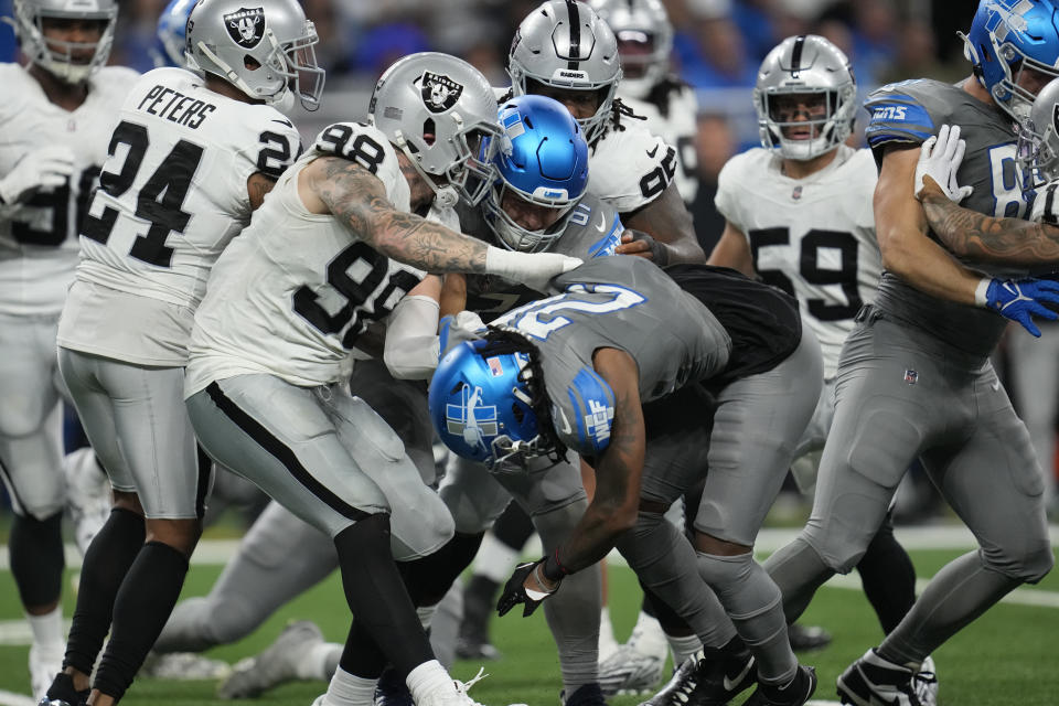 Las Vegas Raiders defensive end Maxx Crosby (98) tackles Detroit Lions running back Jahmyr Gibbs (26) during the first half of an NFL football game, Monday, Oct. 30, 2023, in Detroit. (AP Photo/Paul Sancya)