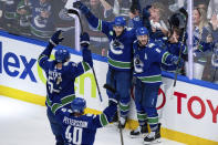 Vancouver Canucks' Carson Soucy, back left, J.T. Miller, back right, Tyler Myers, front left, and Elias Pettersson celebrate Miller's goal against the Edmonton Oilers during the third period of Game 5 of an NHL hockey Stanley Cup second-round playoff series, Thursday, May 16, 2024, in Vancouver, British Columbia. (Ethan Cairns/The Canadian Press via AP)
