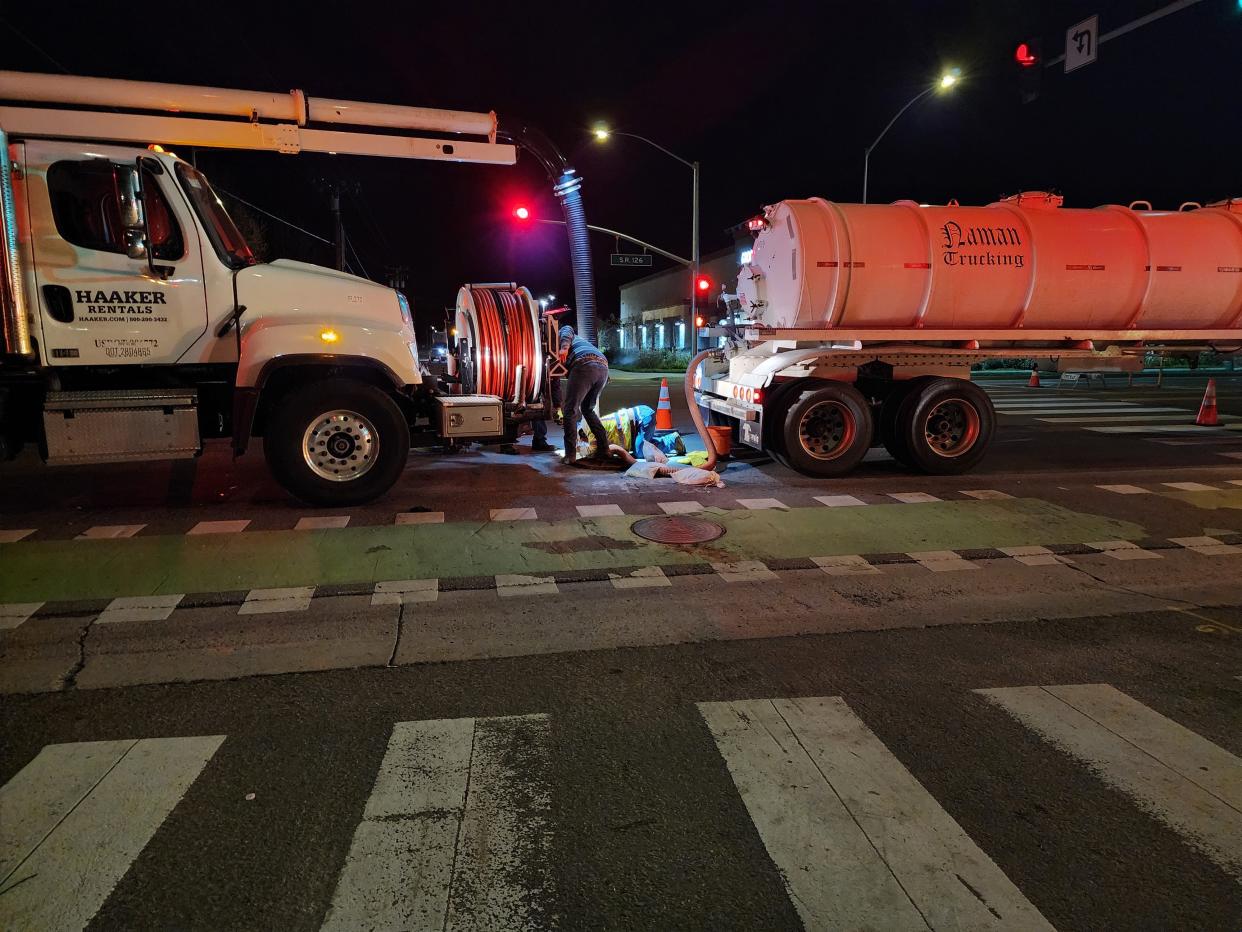 Workers use a tube to repair a manhole in Fillmore on Highway 126 in March. Heavy rain collapsed a sewer line on March 15, and city officials have declared an emergency to expedite repair.