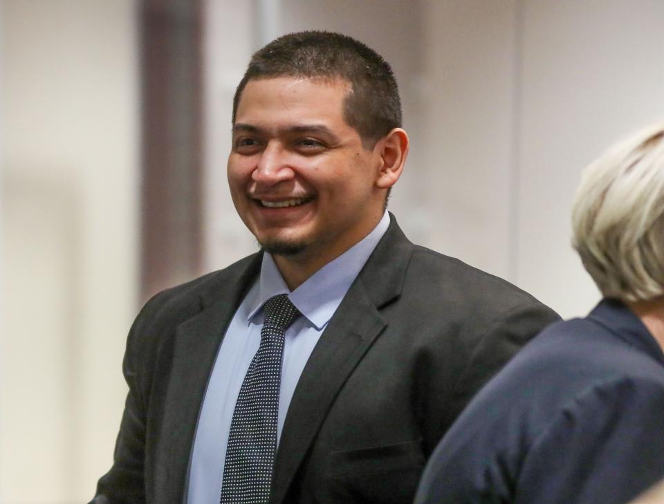 Jose Larin-Garcia smiles as he talks with his lawyers Thursday while the jury enters the courtroom.