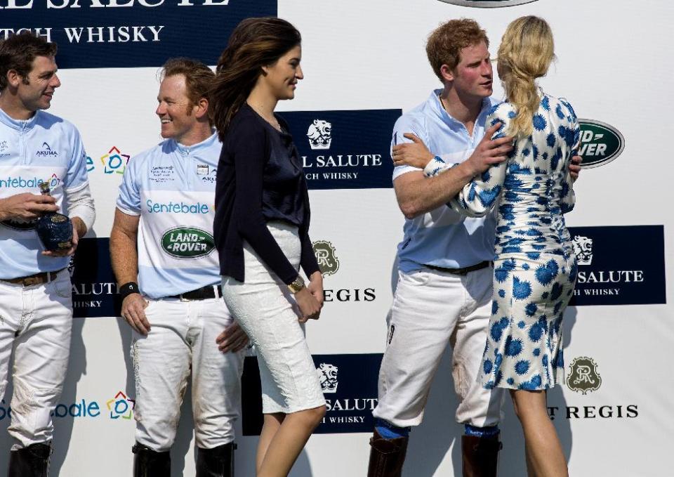 Britain's Prince Harry embraces model Karolina Kurkova after the Sentebale Royal Salute Polo Cup charity match in Greenwich, Conn., Wednesday, May 15, 2013. Teammates Malcolm Borwick, far left, and Marc Ganzi join him on the podium after the Sentebale team won. (AP Photo/Craig Ruttle)
