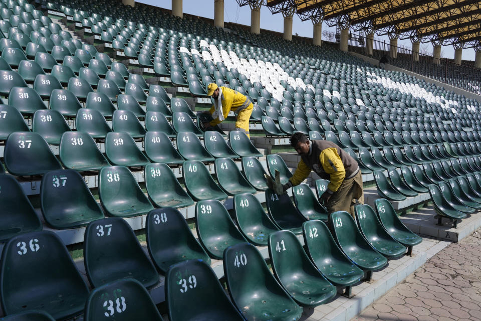 Workers clean seats in preparation for upcoming Pakistan Super League T20 cricket tournament, in Lahore, Pakistan, Thursday, Feb. 15, 2024. Young aspiring fast bowlers such as Shamar Joseph of West Indies will showcase their skills in Pakistan's premier domestic Twenty20 competition starting this weekend. (AP Photo/K.M. Chaudary)