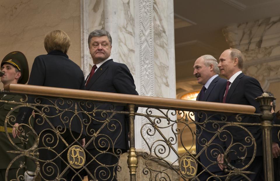 FILE - German Chancellor Angela Merkel, left back to a camera, Ukrainian President Petro Poroshenko, second left, Belarusian President Alexander Lukashenko, second right, and Russian President Vladimir Putin, walk together to continue their peace talks in Minsk, Belarus, Wednesday, Feb. 11, 2015. The 2015 peace agreement for eastern Ukraine brokered by France and Germany was a diplomatic coup for Moscow, obliging Ukraine to give broad powers to the rebel regions. (AP Photo/Alexander Zemlianichenko, File)