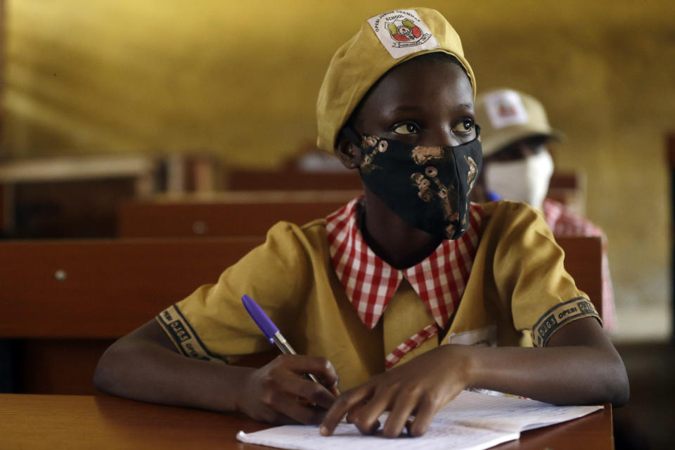 Students from Opebi Junior Grammar School, wearing face masks to protect against coronavirus, attend lessons in Lagos Nigeria, Monday, Jan. 18, 2021. Nigeria officials resumed both public and private schools on Monday for students following months of closure to curb the spread of coronavirus. as cases increase in the country. (AP Photo/Sunday Alamba)