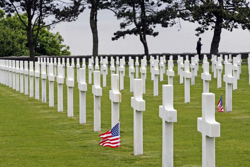 U.S. flags fly between tombs at the Colleville American miltary cemetary, in Colleville sur Mer, western France, Wednesday June 6, 2012, as part of the commemoration of the 68th anniversary of the D-Day.(AP Photo/Remy de la Mauviniere)