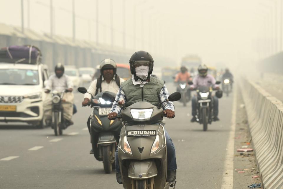 Traffic moves on a road enveloped by fog and smog in New Delhi, India, Friday (AP)