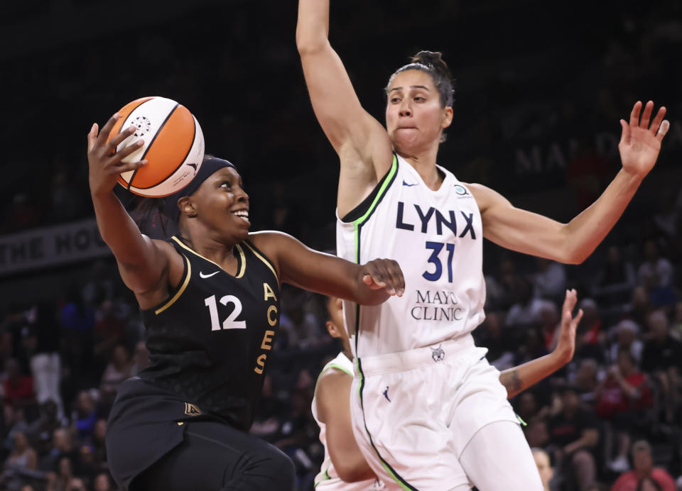 Las Vegas Aces guard Chelsea Gray (12) drives to the basket against Minnesota Lynx center Nikolina Milic (31) during the first half of a WNBA basketball game Sunday, June 19, 2022, in Las Vegas. (Chase Stevens/Las Vegas Review-Journal via AP)