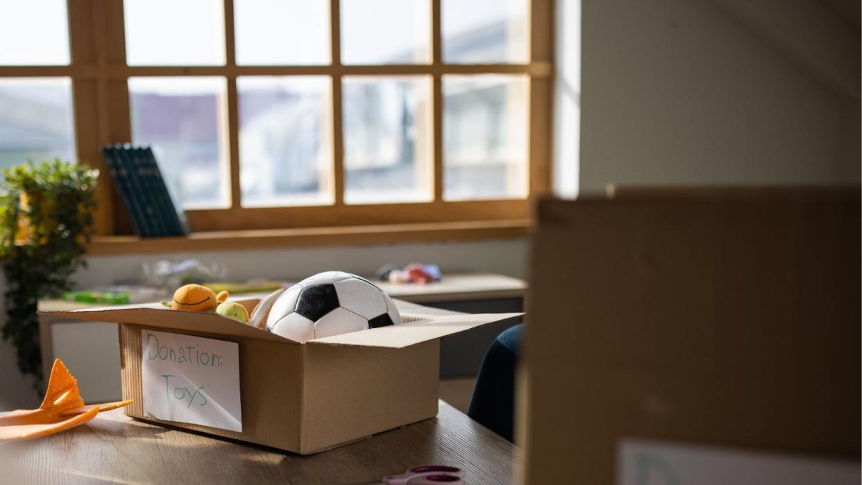  A box of toys on a bed with 'donation' written on it 