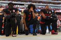 Mit seinem Kniefall und der Weigerung, der US-Hymne ehrfürchtig zu lauschen, wurde Football-Star Colin Kaepernick (Mitte) 2016 berühmt und zu einer Galionsfigur der "Black Lives Matter"-Bewegung: "Ich stehe nicht auf, um Stolz auf eine Flagge für ein Land zu zeigen, das schwarze und farbige Menschen unterdrückt", erklärte der damalige Quarterback der San Francisco 49ers. (Bild: Thearon W. Henderson/Getty Images)