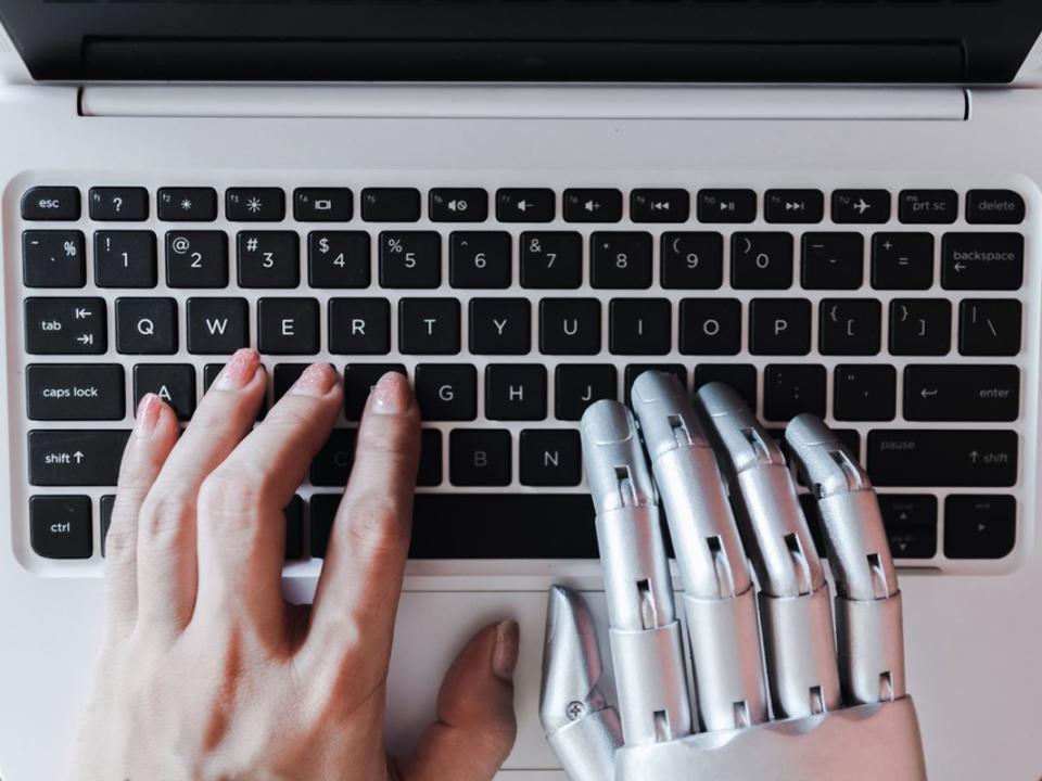 Robot hands and fingers point to laptop button advisor chatbot robotic artificial intelligence concept