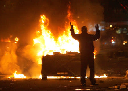 FILE PHOTO: A protester reacts near burning police cars in central Yerevan March 2, 2008. REUTERS/David Mdzinarishvili/Files