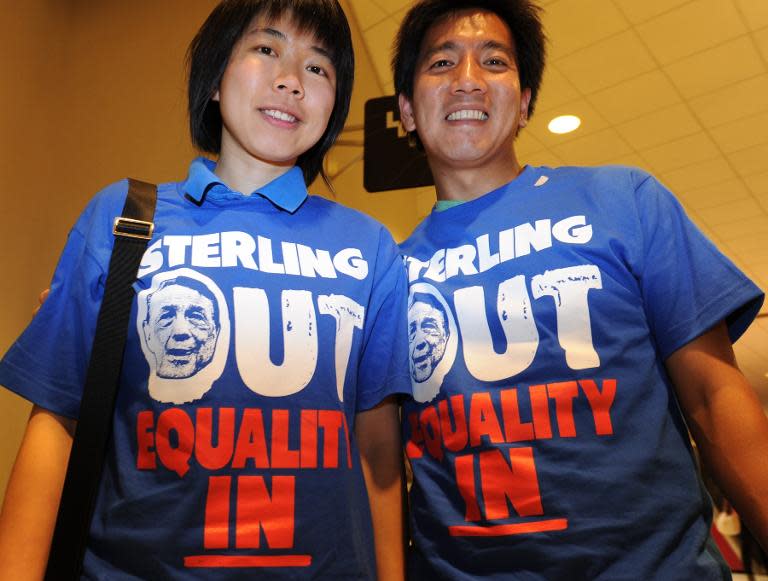 Clippers fans Kitty Siu (L) and Alvy Chen wear shirts calling for Donald Sterling to sell the Los Angeles Clippers at the NBA playoff game on April 29, 2014 at Staples Center in Los Angeles, California