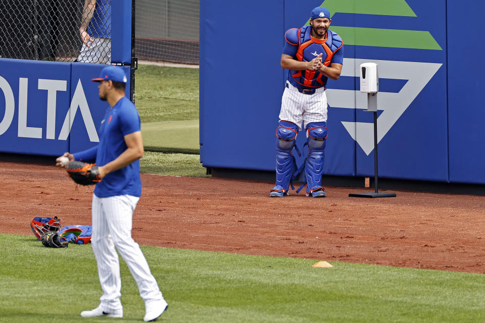 New York Mets catcher Rene Rivera rubs hand sanitizer on his hands as he watches relief pitcher Dellin Betances during a baseball workout at Citi Field in New York, Friday, July 3, 2020.(AP Photo/Adam Hunger)