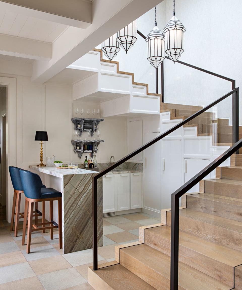 home bar under stairs with blue stools wooden stairs