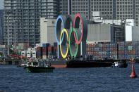 The Olympic Symbol is transported on a barge in the Odaiba section Tuesday, Dec. 1, 2020, in Tokyo. The five Olympic rings are back in Tokyo Bay. They were removed for maintenance four months ago shortly after the Tokyo Olympics were postponed until next year because of the COVID-19 pandemic. (AP Photo/Eugene Hoshiko)