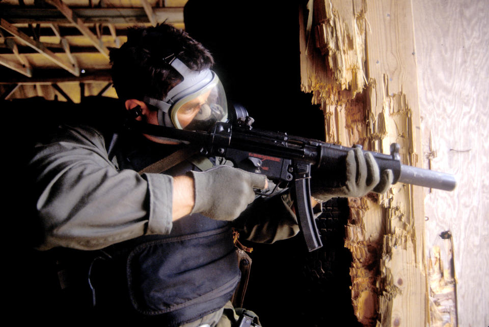 A SEAL conducts CQB, Close Quarter Battle, as he enter a kill house wearing a gas mask and armed with a MP5.  Much of SEALs training is done with live ammunition.  Photo: Greg E. Mathieson Sr. / NSW Publications, LLC