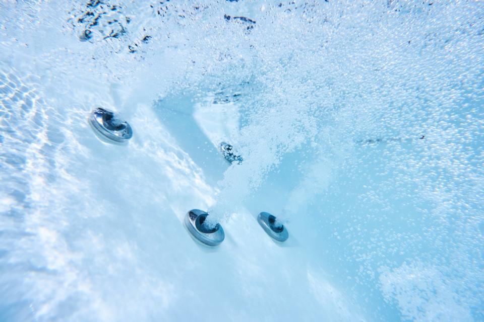 Underwater hot tub jets shooting out water and bubbles. 