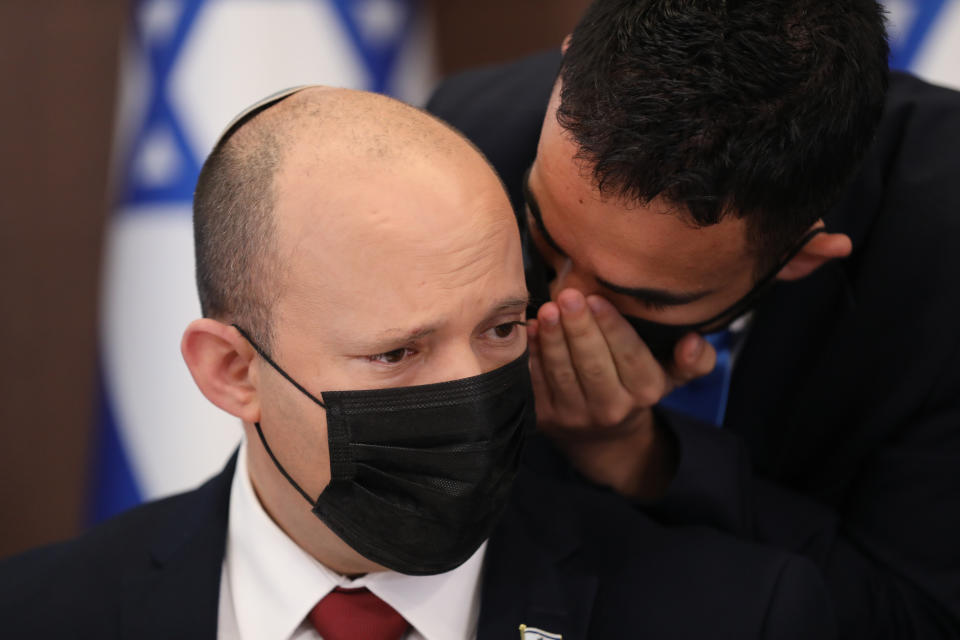 Israeli Prime Minister Naftali Bennett is spoken to as he attends a cabinet meeting at the prime minister's office in Jerusalem, Sunday, Aug. 1, 2021. (Abir Sultan/Pool Photo via AP)