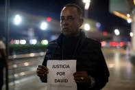 Cesar Ozuna, the father of David de los Santos, holds up a sign saying 'Justice for David' during a protest against his son's death (AFP/Erika SANTELICES)