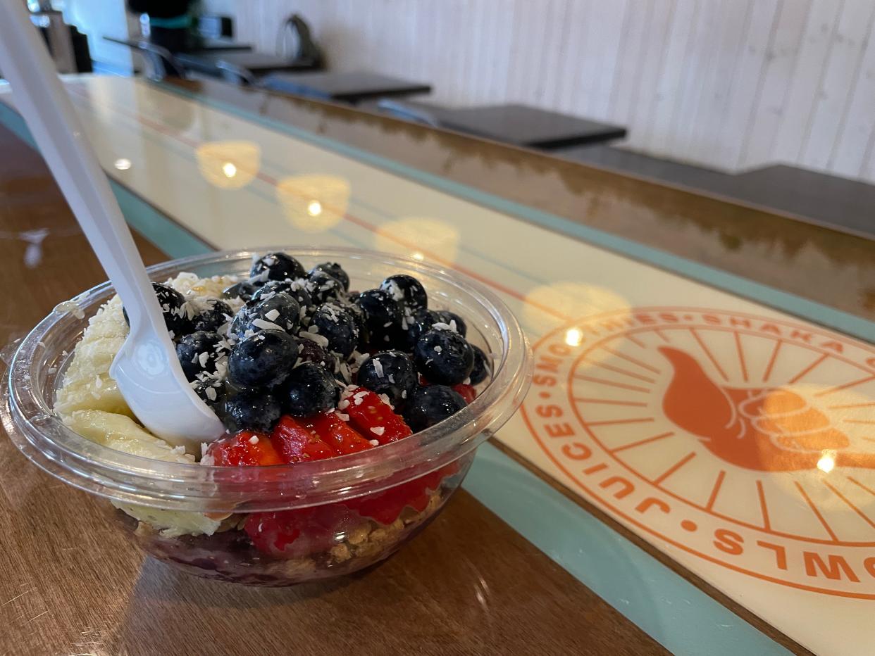 An acai fruit bowl sits on a surfboard-inspired table at Shaka Café in Howell on Tuesday, Oct. 10, 2023.