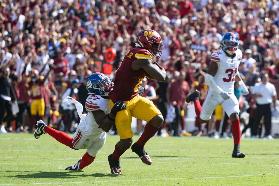 Sep 15, 2024; Landover, Maryland, USA; New York Giants safety Jason Pinnock (27) tackles Washington Commanders running back Brian Robinson Jr. (8) in the second half at Commanders Field. Mandatory Credit: Luke Johnson-Imagn Images