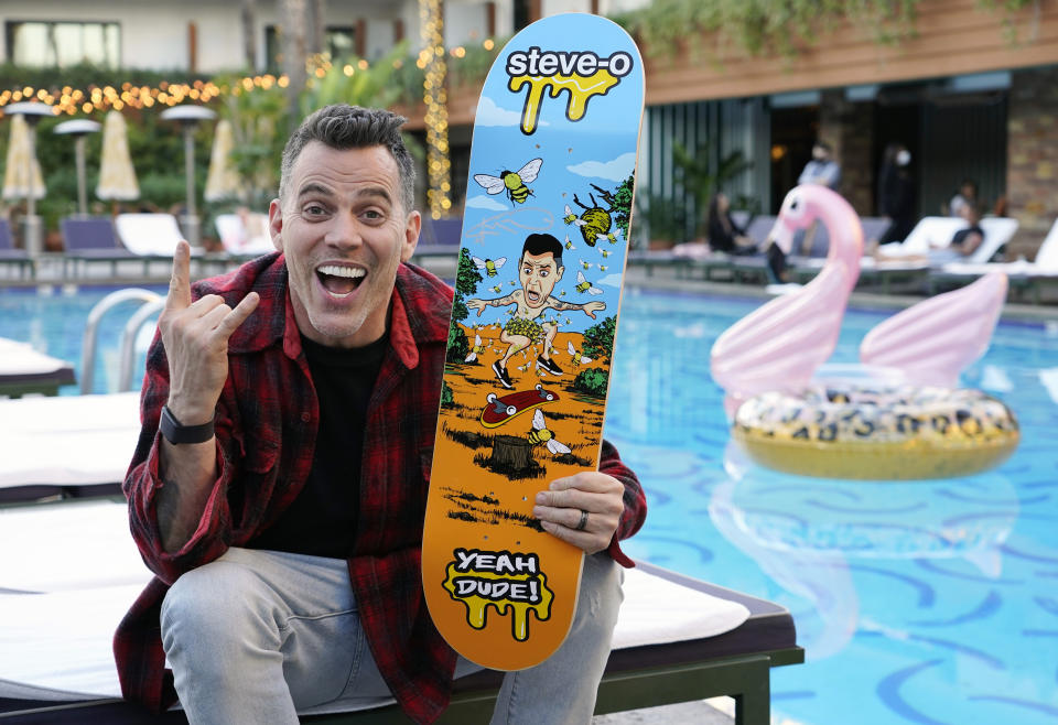 Steve-O, a cast member in the film "Jackass Forever," shows off his skateboard as he poses for a portrait at The Hollywood Roosevelt pool, Thursday, Jan. 27, 2022, in Los Angeles. (AP Photo/Chris Pizzello)