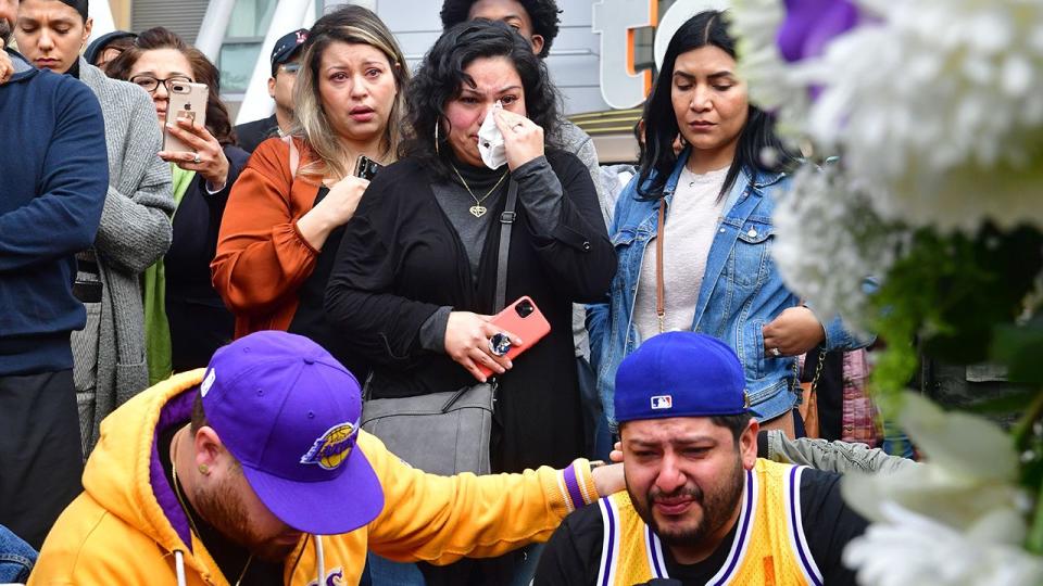 Las personas reunidas alrededor de un monumento improvisado en honor a Kobe Bryant en el Staples Center. (Foto de FREDERIC J. BROWN/AFP vía Getty Images)