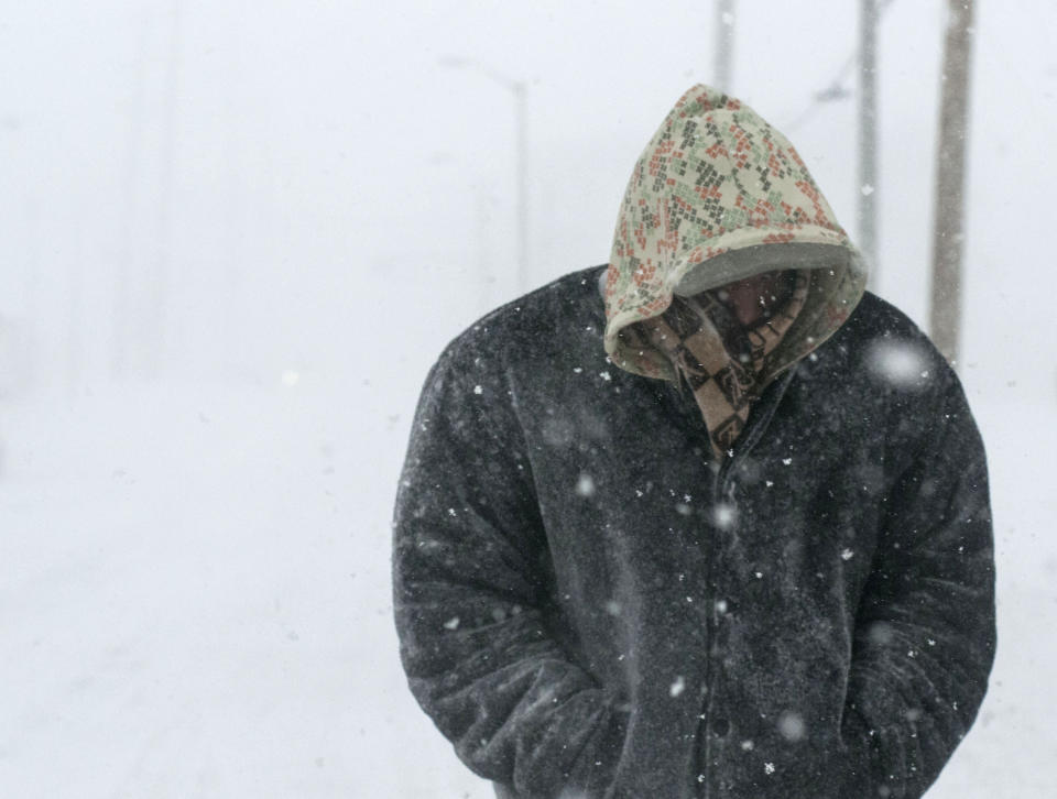 Tyron Smith tries to keep warm as he walks down Bradley Avenue in Champaign, Ill., Sunday Jan. 5, 2014. Icy, snow-covered roads and high winds made travel treacherous from the Dakotas and Michigan to Missouri as much of the nation braced for the next winter wallop: a dangerous cold that could break records. (AP Photo/The News-Gazette, Holly Hart) MANDATORY CREDIT