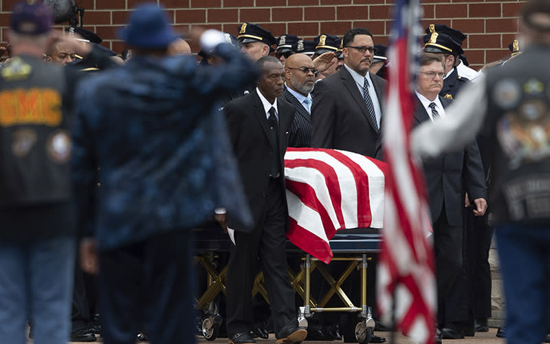 Pallbearers wheel the flag-draped casket of Aaron Salter Jr.