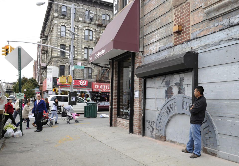 Feliciano Perez guards the work by British graffiti artist Banksy on Saturday, Oct. 19, 2013, in the Brooklyn borough of New York. The building owner has hired security guards and installed a metal gate to protect a work by Banksy. Cara Tabachnick, whose family owns the building, said the goal is to preserve the artwork "so it can be viewed and enjoyed." Most of the Banksy works that have gone up have been tagged over by others, and some have been completely erased. Mayor Michael Bloomberg said last week that graffiti ruins property and is "a sign of decay." (AP Photo/Alyssa Goodman)